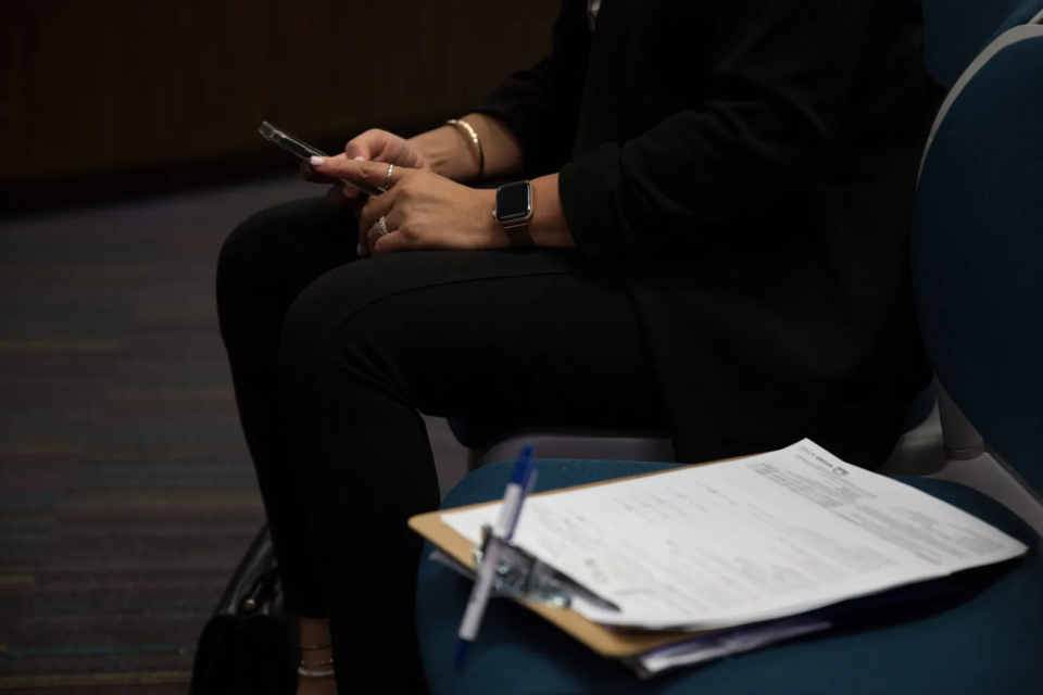 A family member sitting in the waiting room of SFUSD’s Enrollment Center has filled out an application two days before the start of the 2023-24 school year and waits to speak with an enrollment counselor. (Sonya Abrams/The Hechinger Report)