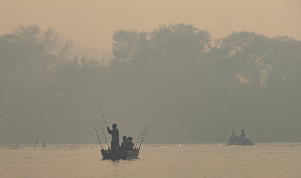 Hombres pescan en el río Cuiabá en medio del humo de los incendios en el parque Encontro das Aguas en los humedales del Pantanal cerca de Pocone, estado de Mato Grosso, Brasil, el domingo 13 de septiembre de 2020. (AP Foto/Andre Penner)