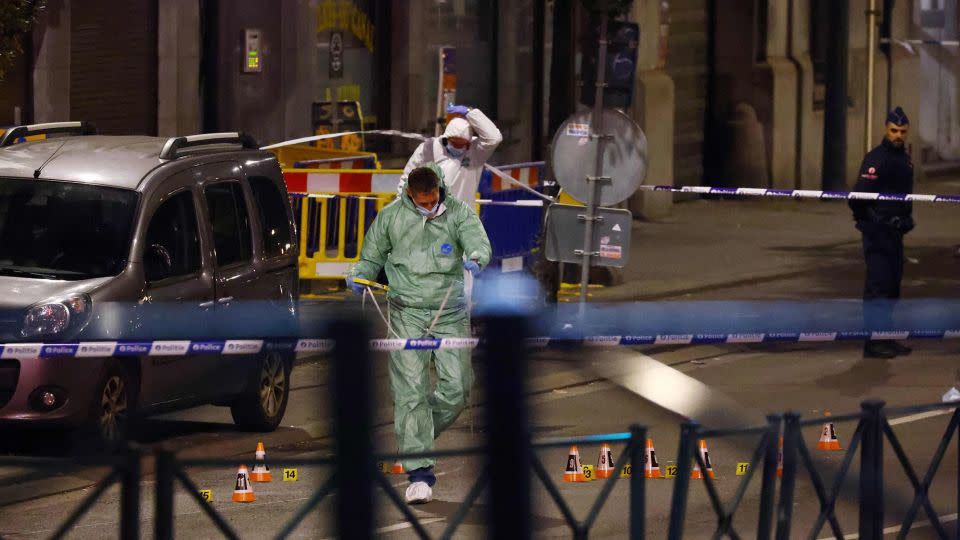 Belgian police officers from the forensic service search for evidence in a street. - Kenzo Tribouillard/AFP/Getty Images