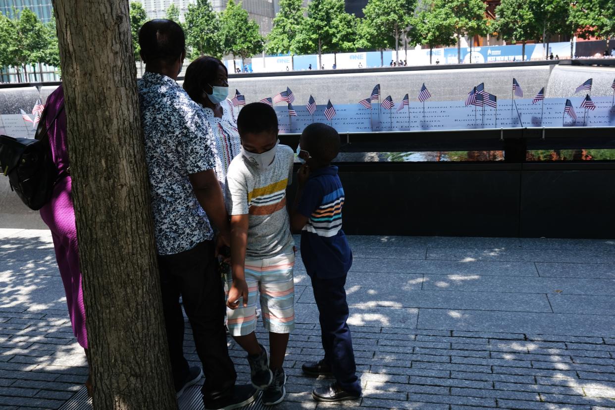 People gather at the 9/11 Memorial Plaza on the first day that it has reopened after closing for three months because of the coronavirus on July 4, 2020, in New York City.