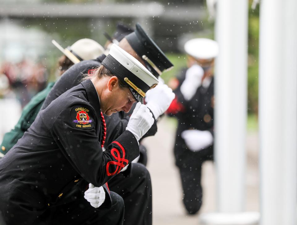 Oregon Fire Service Honor Guard members kneel facing the memorial during the Fallen Firefighters Memorial Ceremony on Thursday, June 9, 2022 in Salem, Ore. 