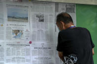 A man reads newspapers reporting on China's air and naval forces of the Eastern Theater Command of the Chinese People's Liberation Army (PLA) conducting exercises and China sanction against United States of America, at a stand in Beijing, Sunday, Aug. 7, 2022. U.S. Secretary of State Antony Blinken said Saturday that China should not hold hostage talks on important global matters such as the climate crisis, after Beijing cut off contacts with Washington in retaliation for U.S. House Speaker Nancy Pelosi's visit to Taiwan earlier this week. (AP Photo/Andy Wong)