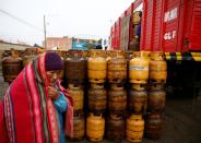 A woman stands next to gas cylinders near petrol plant of Senkata, that normalizes fuel distribution in El Alto outskirts of La Paz