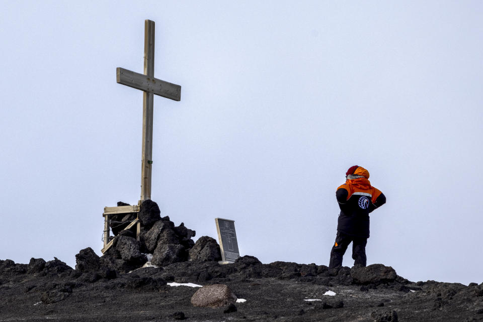 New Zealand Prime Minister Jacinda Ardern examines the cross in place above Sir Robert Falcon's hut at Cape Evans in Antarctica, Thursday, Oct. 27, 2022. (Mike Scott/NZ Herald via AP, Pool)