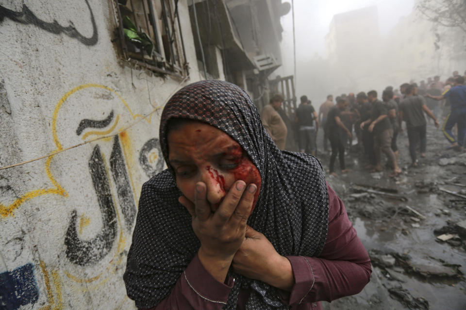 A wounded Palestinian woman runs away following Israeli airstrikes that targeted her neighborhood in Gaza City on Monday, Oct. 23, 2023. (AP Photo/Abed Khaled)