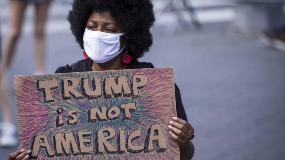 A protester holds a homemade sign that says, “Trump is Not America” in the middle of the crowd that gathered at Columbus Circle in New York City. (Photo by Ira L. Black/Corbis via Getty Images)