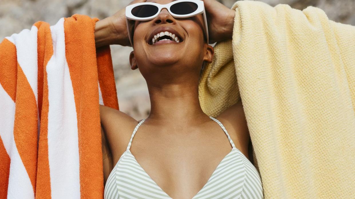 woman in bikini holding towels