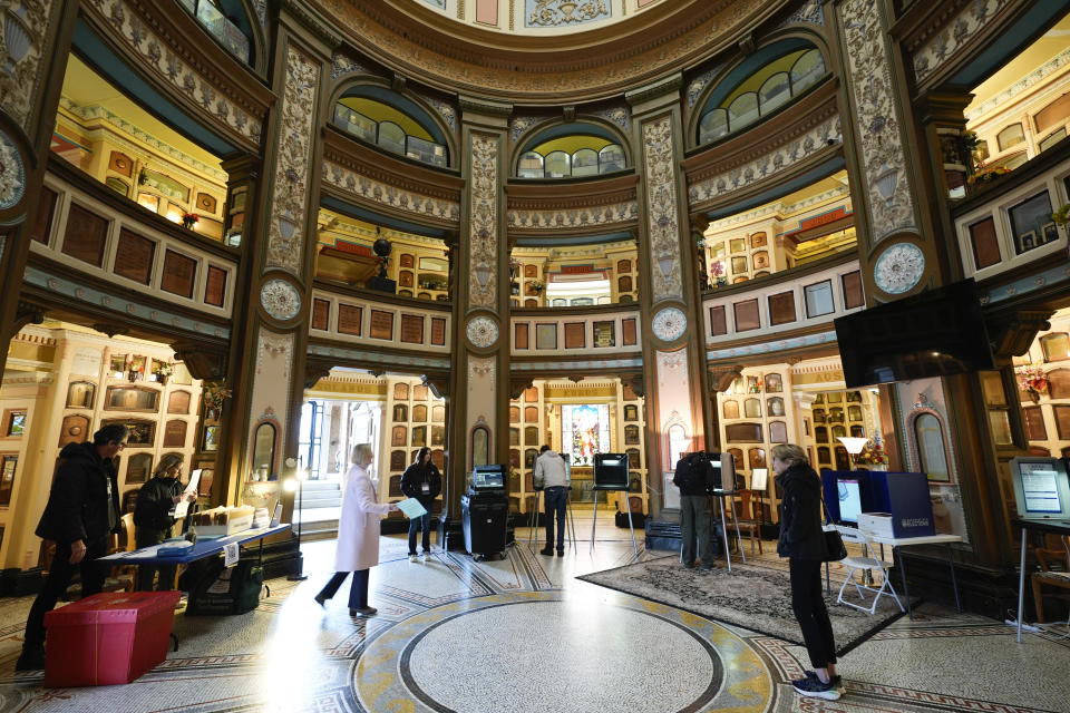 Paula Romanovsky carries her ballot to vote in a booth at the Columbarium in San Francisco, Tuesday, March 5, 2024. The building dates to 1898 and contains over 8,500 niches. (AP Photo/Eric Risberg)