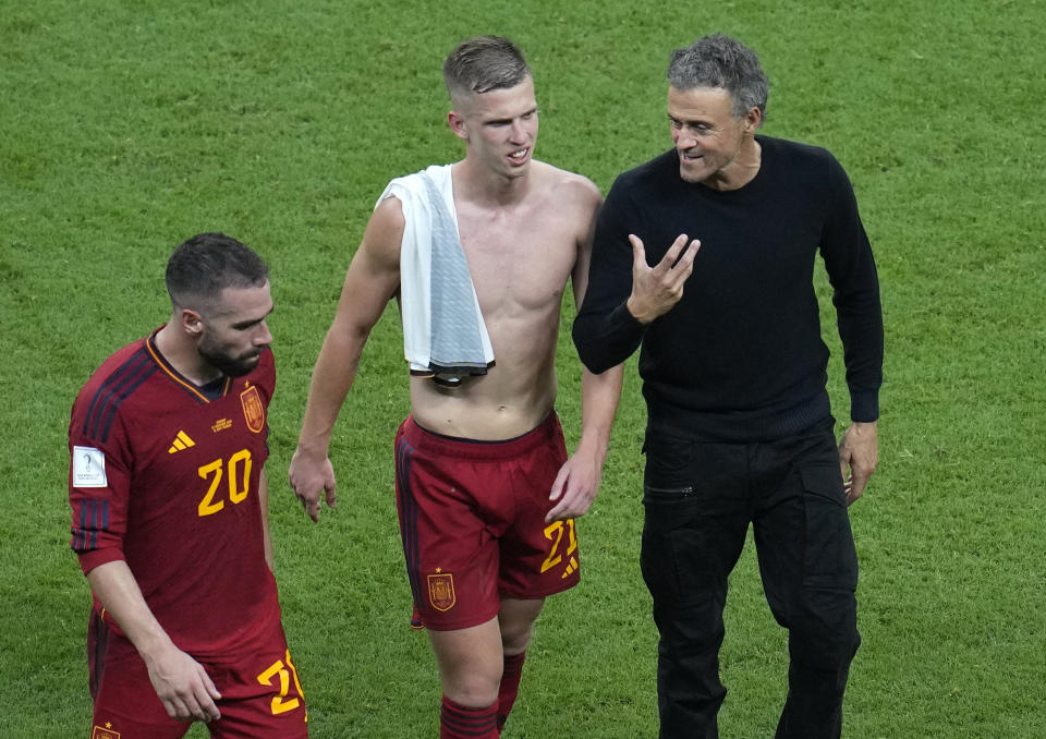 Spain's head coach Luis Enrique leaves the field with Spain's Dani Carvajal, left, and Spain's Dani Olmo at the end of the World Cup group E soccer match between Spain and Germany, at the Al Bayt Stadium in Al Khor, Qatar, Sunday, Nov. 27, 2022. (AP Photo/Ricardo Mazalan)