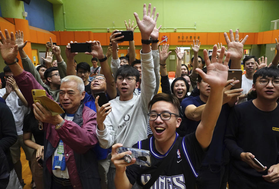 Partidarios del candidato pro democracia Angus Wong festejan después de que ganó en las elecciones de los consejos de distrito en Hong Kong, el lunes 25 de noviembre de 2019 en la madrugada. (AP Foto/Vincent Yu)