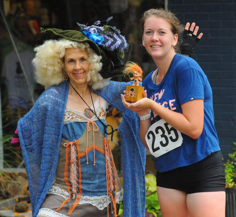 Alyssa Lynch holds up her troll trophy alongside Sherry Groom, as Sigrid the Troll Queen. Lynch won the Troll Hobble 5K race on Sunday, Sept. 25, 2022, in Alliance.