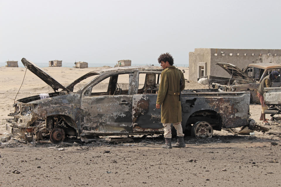 FILE - In this Aug. 30, 2019 file photo, a Yemeni southern separatist fighter inspects the wreckage of government forces vehicles destroyed by UAE airstrikes in near Aden, Yemen. Fighting between their allies in southern Yemen has opened a gaping wound in the Saudi Arabia and the United Arab Emirates’ coalition fighting the country’s rebels. If they can’t fix it, it threatens to further fragment the country into smaller warring pieces. (AP Photo/Wail al-Qubaty, File)