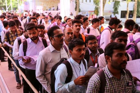 FILE PHOTO: Job seekers line up for interviews at a job fair in Chinchwad