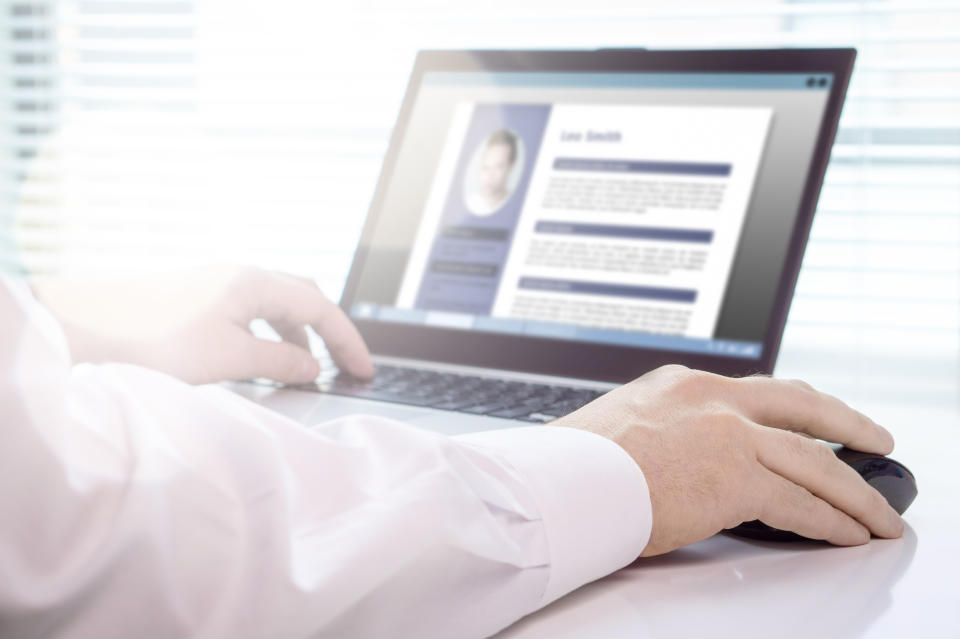 A jobseeker writing his CV on a laptop