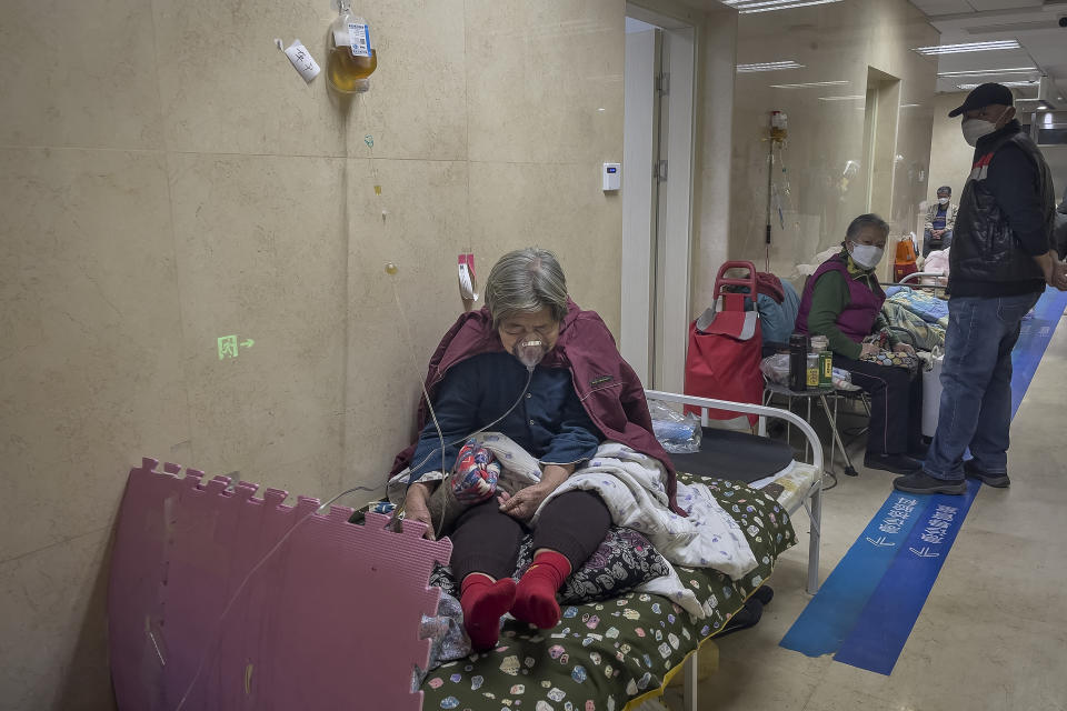 An elderly patient receives an intravenous drip while using a ventilator in the hallway of the emergency ward at a hospital in Beijing, Thursday, Jan. 5, 2023. Patients, most of them elderly, are lying on stretchers in hallways and taking oxygen while sitting in wheelchairs as COVID-19 surges in China's capital Beijing. (AP Photo/Andy Wong)