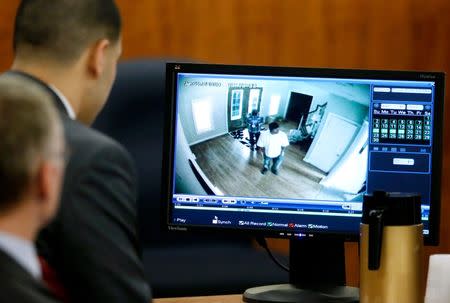 Former New England Patriots football player Aaron Hernandez (L), sits with his defense attorney Charles Rankin as surveillance video from June 17, 2013 is displayed on at monitor during his murder trial in Fall River, Massachusetts March 26, 2015. REUTERS/Steven Senne/Pool