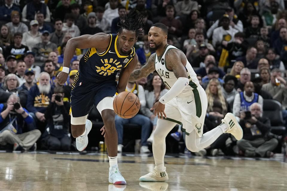 Indiana Pacers' Aaron Nesmith (23) makes a steal as Milwaukee Bucks' Damian Lillard (0) looks on during the first half of an NBA basketball game, Wednesday, Jan. 3, 2024, in Indianapolis. (AP Photo/Darron Cummings)