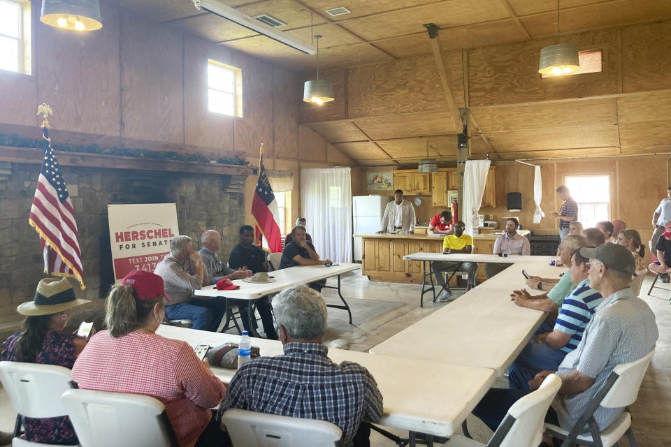 Republican U.S. Senate nominee Herschel Walker talks with north Georgia farmers on Thursday, July 21, 2022, in Alto, Ga., as he campaigns to unseat Democratic Sen. Raphael Warnock in a contest that will help determine which party controls the Senate the second half of President Joe Biden’s term. (AP Photo/Bill Barrow)