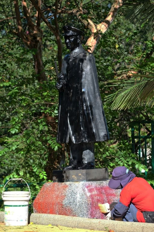 A worker cleans paint off the statue of the late nationalist leader Chiang Kai-shek in the northern city of Keelung