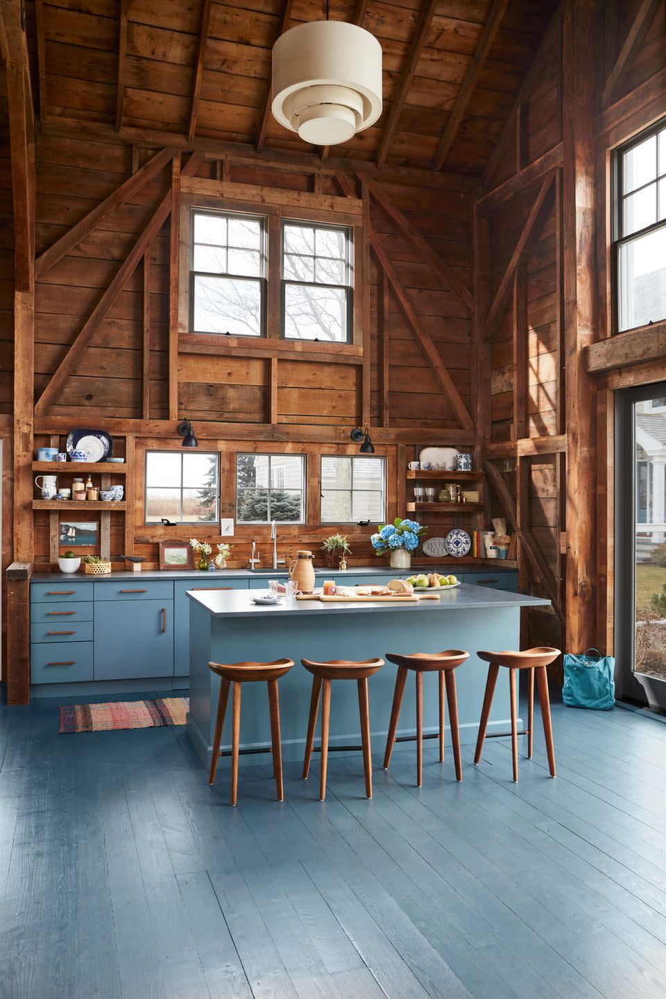 rustic kitchen with wood walls and modern blue cabinets