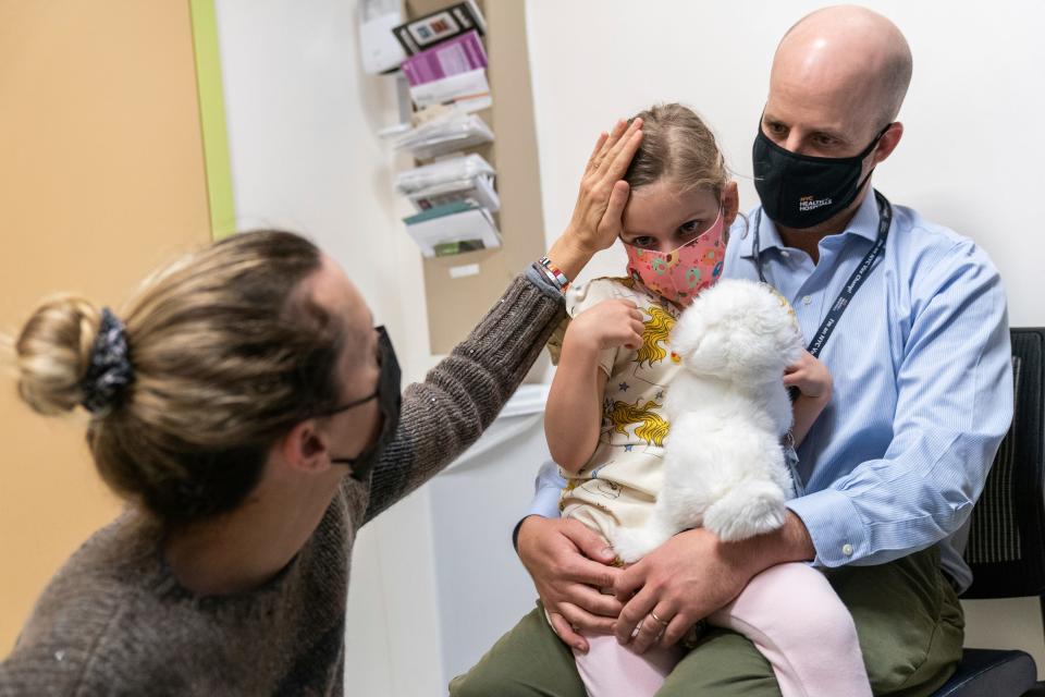 Ashley Peterson, left, comforts her daughter, Ella Seigler, 5, before she is inoculated with her first dose of the Pfizer-BioNTech COVID-19 vaccine for children from five to 12 years at NYC Health + Hospitals Harlem Hospital in New York.