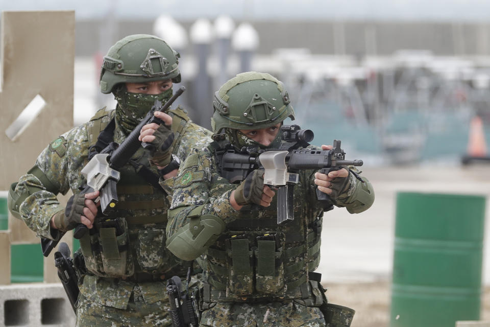 Soldiers perform moving shooting as Taiwan President Tsai Ing-wen inspects the Penghu Magong military base in outlying Penghu Island, Taiwan, Friday, Dec. 30, 2022. Taiwan President Tsai thanked the men and women serving in the navy and army Friday for holding up the island's defense, after China sent a record-breaking number of warplanes and ships towards the island this week. (AP Photo/ Chiang Ying-ying)