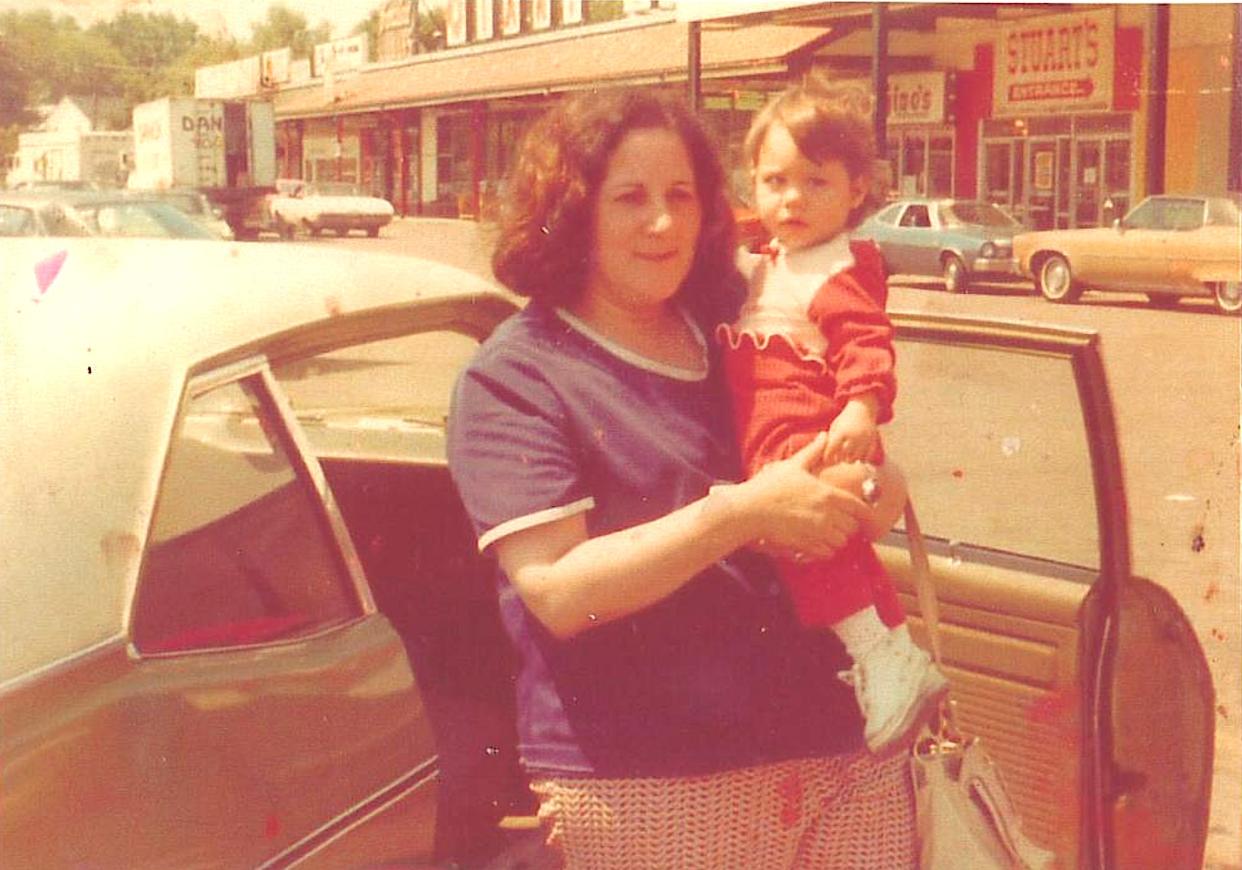 Nicole Johnson with her foster mother, Esther, when she was younger. They are standing outside a car.