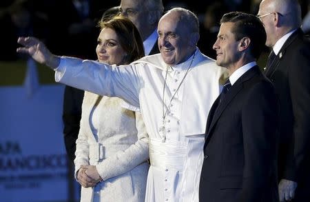 Pope Francis (C) waves while walking with Mexico's first lady Angelica Rivera (L) and Mexico's President Enrique Pena Nieto after his arrival in Mexico City, February 12, 2016. REUTERS/Max Rossi