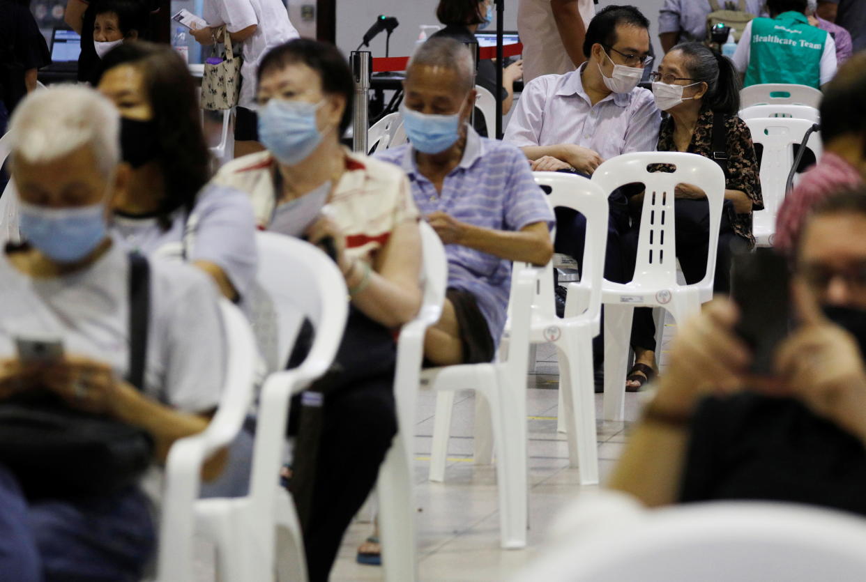 Tan Liat Leng, 39, accompanies her mother Lim Bing, 78 to get her coronavirus disease (COVID-19) vaccine at a vaccination center in Singapore January 27, 2021. REUTERS/Edgar Su