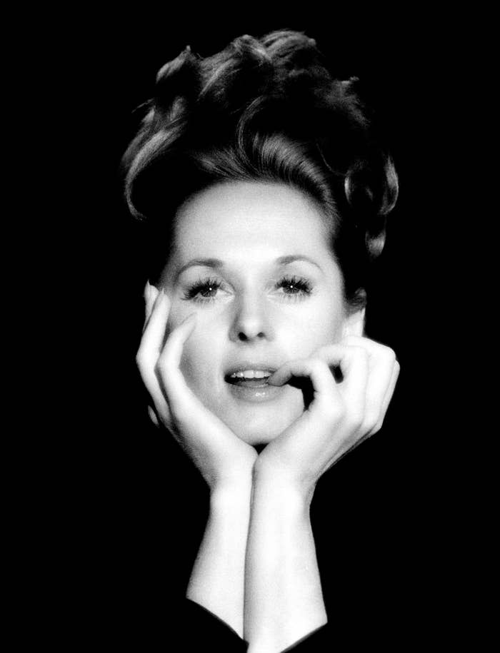 Hedren poses for a photo with her head in her hands in front of a black background