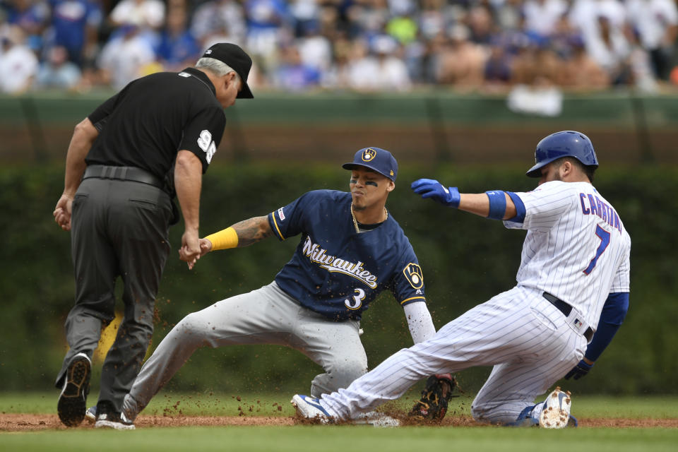 Milwaukee Brewers shortstop Orlando Arcia (3) tags out Chicago Cubs' Victor Caratini (7) at second base during the first inning of a baseball game Friday, Aug 30, 2019, in Chicago. (AP Photo/Paul Beaty)