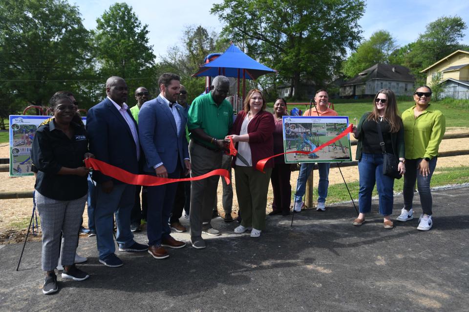 Director of Recreations & Parks Tony Black cuts a ribbon during the unveiling of the newly renovated Paradise Park playground in Jackson, Tenn., on Monday, April 15, 2024. Paradise Park is one of three parks in the city to recieve new playgrounds.