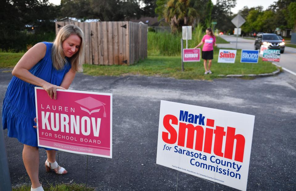 Sarasota County School Board candidate Lauren Kurnov places campaign signs outside the polling place at Trinity United Methodist Church in Sarasota early Tuesday morning on Primary Election Day, Aug. 23, 2002. 