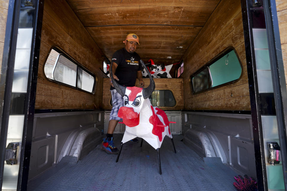 Fireworks artisan Francisco Cortes loads paper-mache "toritos" or bulls into the back of his, to deliver to clients ahead of the annual festival in honor of Saint John of God, the patron saint of the poor and sick whom fireworks producers view as a protective figure, in Tultepec, Mexico, Tuesday, March 5, 2024. (AP Photo/Marco Ugarte)