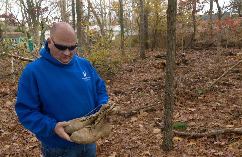 Paul Hulse stands on the site of the future Larry's Home in Little Egg Harbor. Larry's Home will be a transitional shelter for homeless veterans named in honor of the late Larry Robertello. The boots belonged to Robertello and Hulse has been carrying them in his truck since his friend passed away in April 2022 of an accidental overdose.
