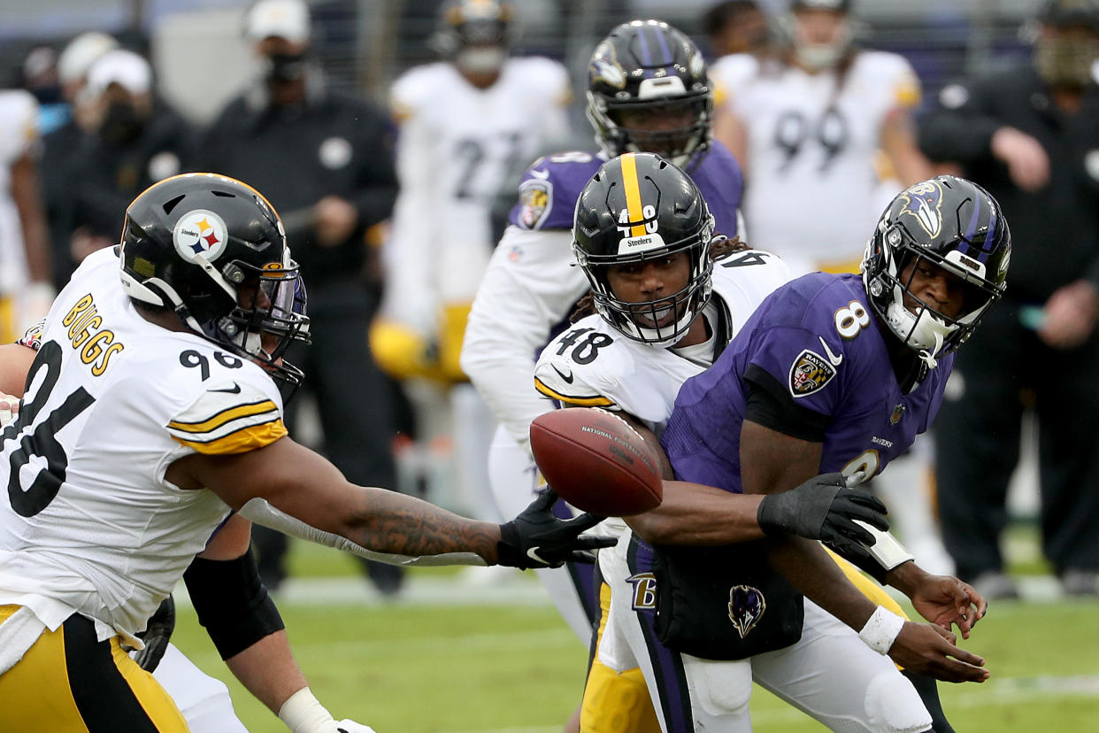 Outside linebacker Bud Dupree and defensive end Isaiah Buggs of the Pittsburgh Steelers pressure quarterback Lamar Jackson. (Photo by Patrick Smith/Getty Images)