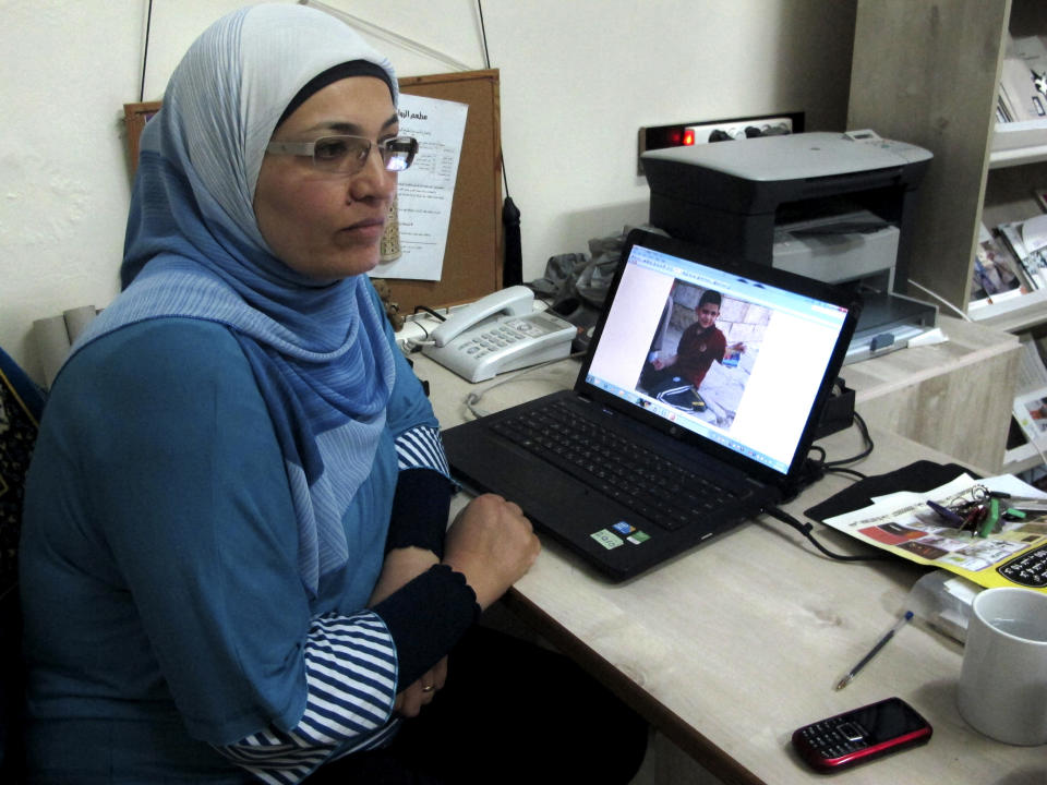 In this photo taken Wednesday, Aug. 29, 2012, Hekmat Besesso, a Palestinian woman's rights advocate, sits beside a laptop that shows an image of her son, Yazan, 6, in the West Bank city of Ramallah. Besesso, a divorce, lost custody of her son after she remarried _ a quirk of Palestinian law. Now, she says, her husband wont let her see him once a week, in accordance with her visitation rights. (AP Photo/Diaa Hadid)