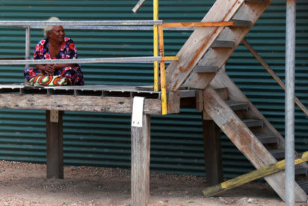 A woman sits on a staircase at her house located near the ExxonMobil PNG Limited operated Liquefied Natural Gas (LNG) plant in the village of Papa Lea Lea located at Caution Bay on the outskirts of Port Moresby, Papua New Guinea, November 19, 2018. Picture taken November 19, 2018. REUTERS/David Gray