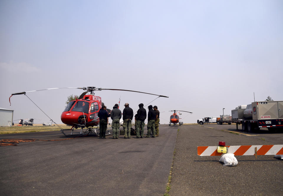 A helitack crew is briefed at the municipal airport near Las Vegas, N.M., on Wednesday, May 4, 2022. Helicopter crews fighting a massive wildfire in the area were grounded much of Wednesday because of high winds. (AP Photo/Thomas Peipert)