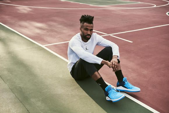 A basketball player sitting on the edge of the court