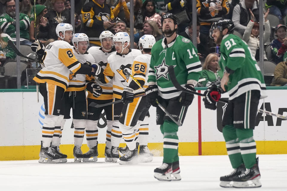 Pittsburgh Penguins Brian Dumoulin (8), Jake Guentzel (59), Sidney Crosby (87), Evan Rodrigues and Kris Letang (58) celebrate scoring a goal against Dallas Stars Jamie Benn (14) and Tyler Seguin (91) during the first period of an NHL hockey game in Dallas, Saturday, Jan. 8, 2022. (AP Photo/LM Otero)