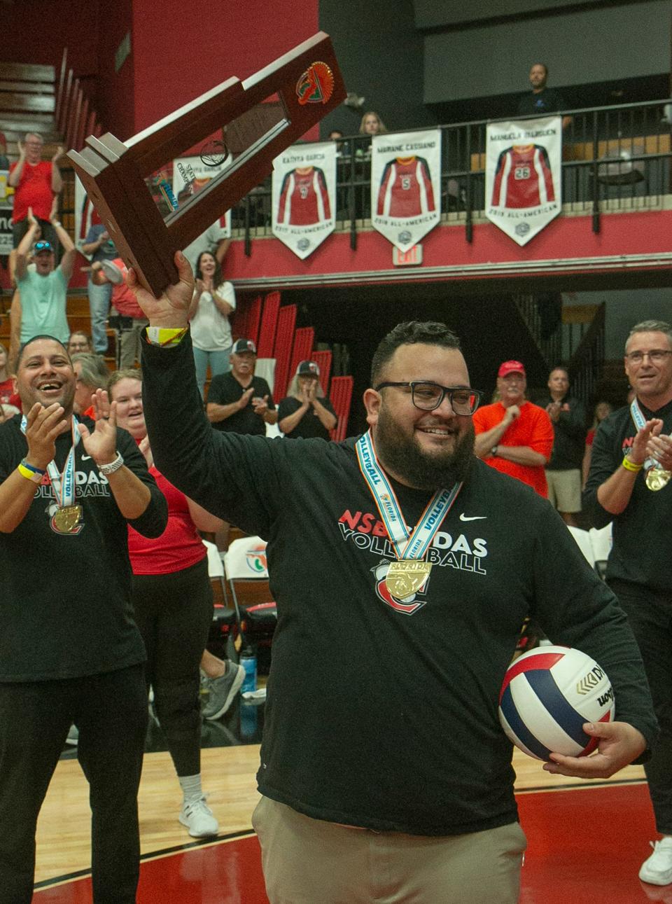 New Smyrna Beach head coach Alvaro Sanchez hoists the state championship trophy before handing it off to his players after their victory over Viera during the FHSAA Class 6A State Championship match at Polk State College in Winter Haven Sunday, Nov. 13, 2022. (Photo: MICHAEL WILSON/SPECIAL TO USA TODAY NETWORK-FLORIDA)