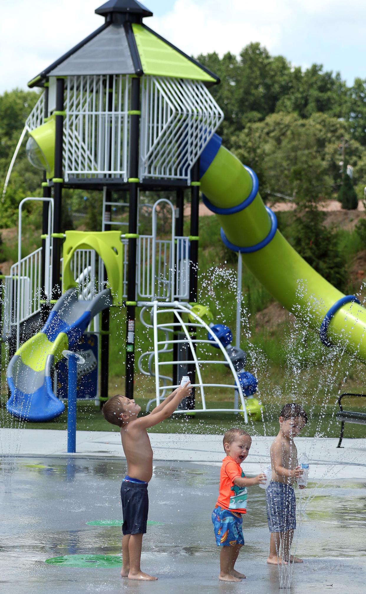 Kids cool off in the water feature on the playground at Stinger Park on North 12th Street in Bessemer City Thursday afternoon, July 6, 2023.