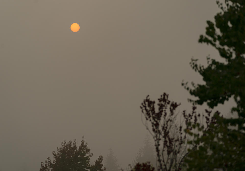 The sun appears orange through wildfire smoke, Wednesday, Sept. 16, 2020, in Olympia, Wash. The smoke from dozens of wildfires that have been raging across the western United States has now drifted thousands of miles across North America, blanketing parts of Canada and Mexico while treating the East Coast to unusually hazy skies and remarkable sunsets. (AP Photo/Ted S. Warren)