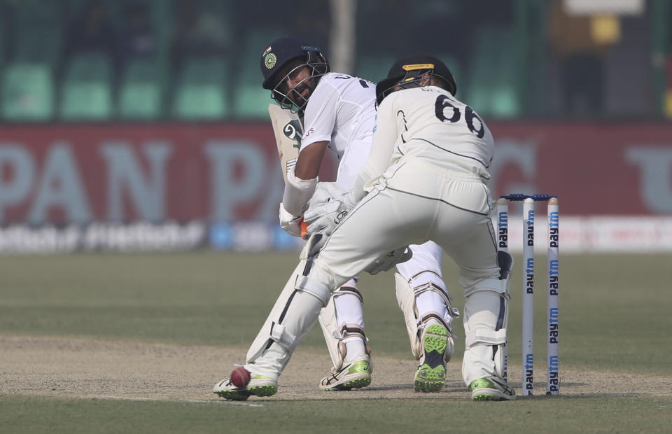 India's Cheteshwar Pujara plays a shot during the day one of their first test cricket match with New Zealand in Kanpur, India, Thursday, Nov. 25, 2021. (AP Photo/Altaf Qadri)