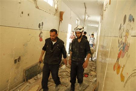 Civil Defence staff walk at Ain Jalout school that was hit by what activists said was an airstrike by forces loyal to Syria's President Bashar al-Assad in Aleppo's al-Ansari al-Sharqi neighbourhood April 30, 2014. REUTERS/Ammar Abdullah