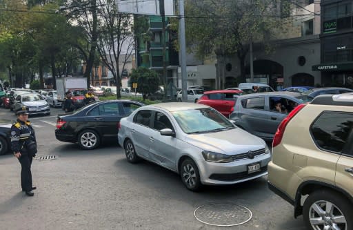 A traffic officer watches over a busy road in Mexico City on November 20, 2019