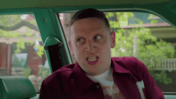 Tim Robinson screams at the top of his lungs in a car