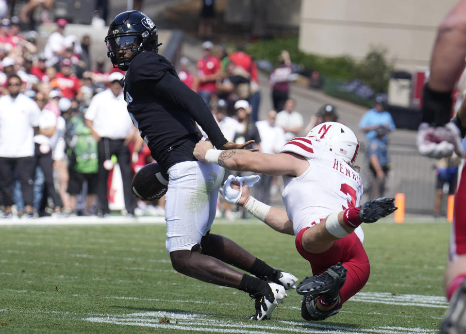 Colorado quarterback Shedeur Sanders, left, escapes from Nebraska linebacker Nick Henrich in the second half of an NCAA college football game Saturday, Sept. 9, 2023, in Boulder, Colo. (AP Photo/David Zalubowski)