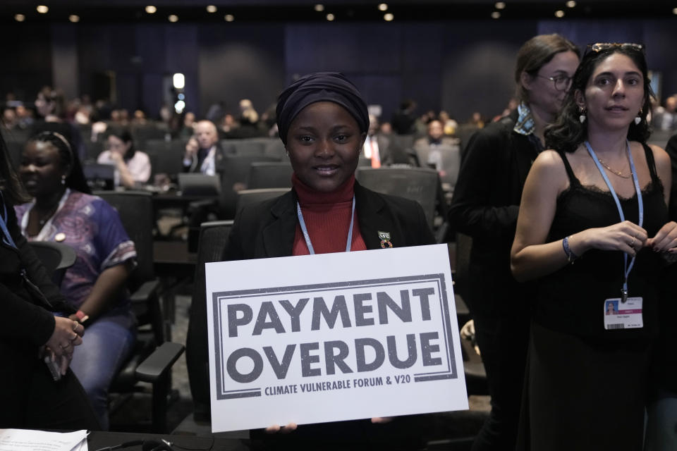 Nakeeyat Dramani Sam, of Ghana, holds a sign that reads "payment overdue" at the COP27 U.N. Climate Summit, Friday, Nov. 18, 2022, in Sharm el-Sheikh, Egypt. She made a plea for negotiators at the summit to come to an agreement that could help curb global warming. (AP Photo/Nariman El-Mofty)